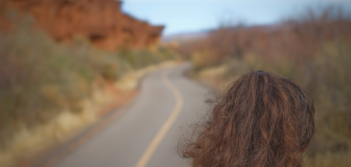 a women looking athe road between hills